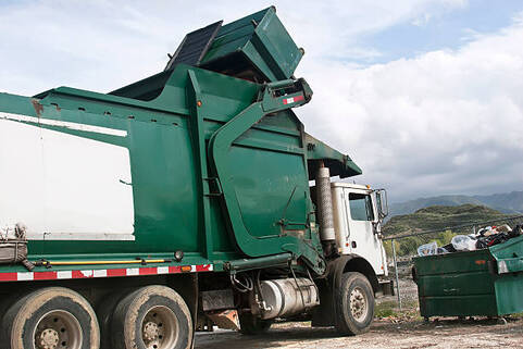 A green dumpster truck in Norwalk, CT.