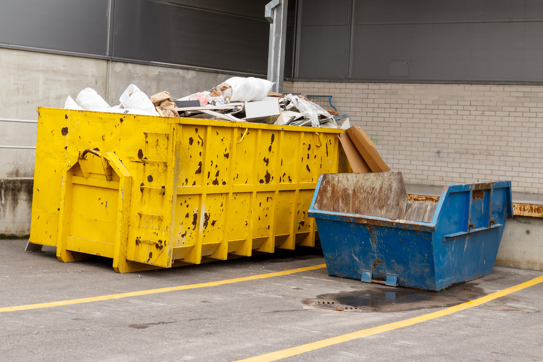 Yellow and blue dumpsters at a commercial Norwalk, CT location.